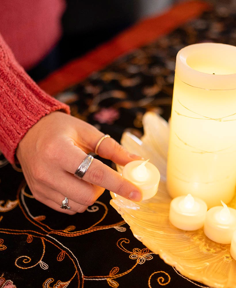 Student placing small candles in circle around large candle