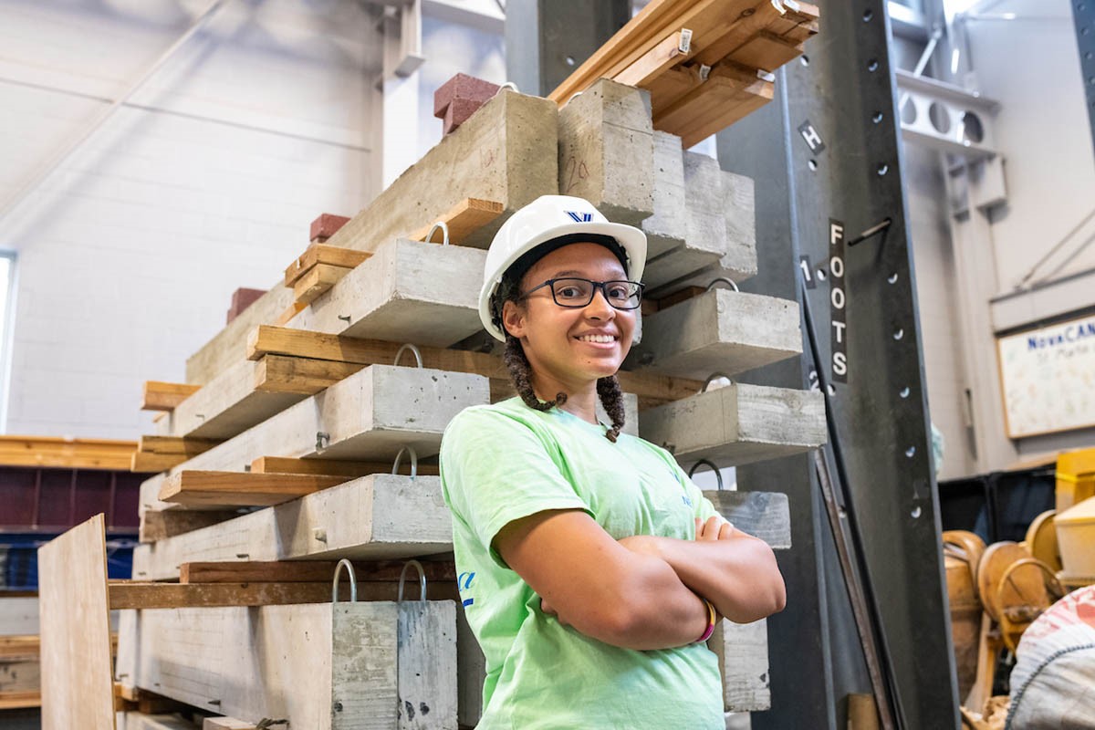 A student posing in a hard hat with their arms crossed