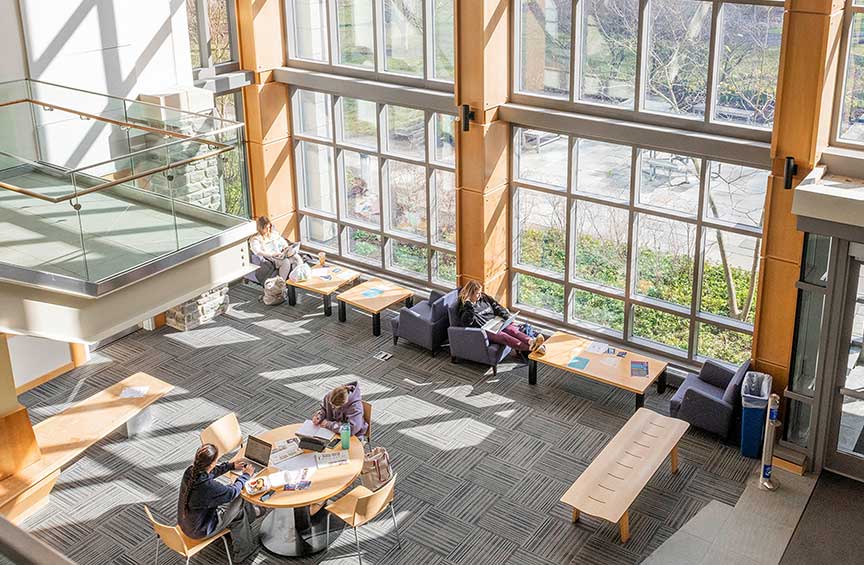 Interior view of a building on Cabrini’s campus, with lots of windows and students studying.